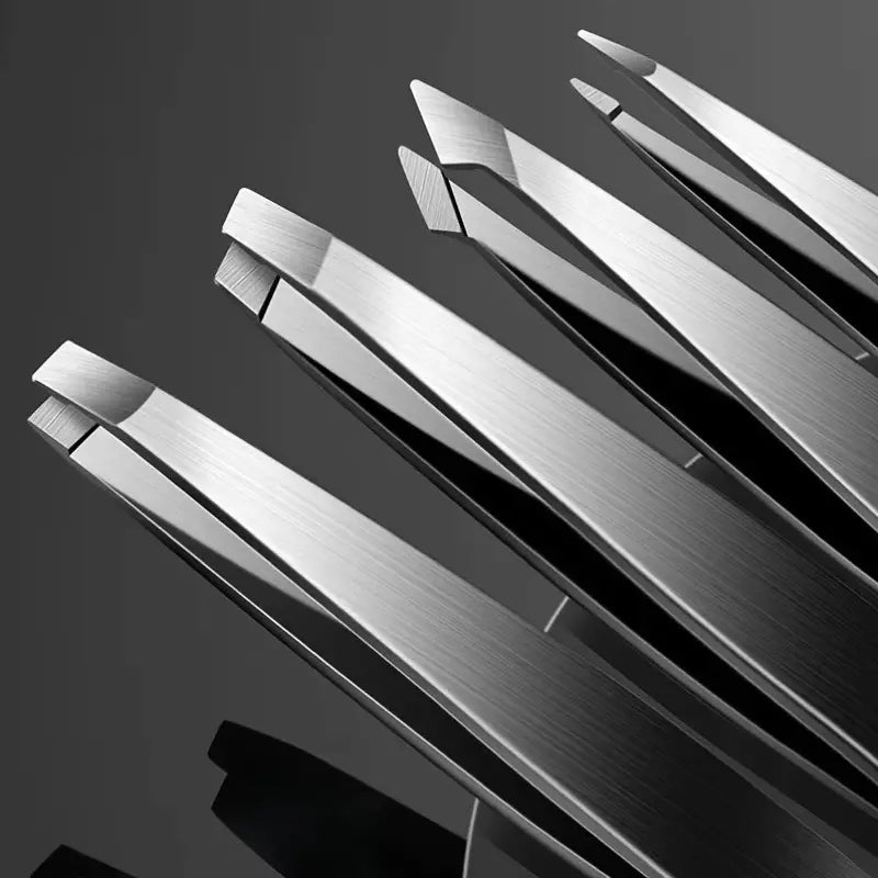 Close-up of metallic tweezers on a reflective surface with a dark background